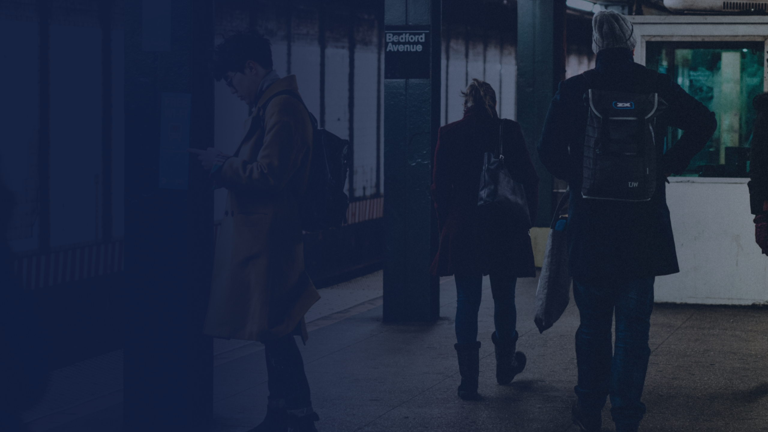 A subway station scene at Bedford Avenue with people waiting or walking